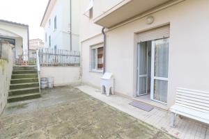 un edificio bianco con panchina e finestra di Appartamenti Vacanze Roberta a San Vincenzo