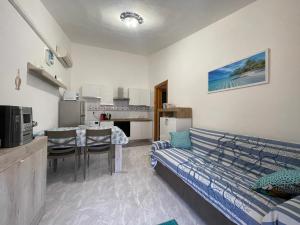 un soggiorno con divano e cucina di Casa Vale a Villasimius Altre 14 foto