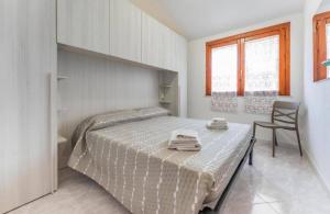 una camera da letto con un letto con due asciugamani sopra di Casa Vale a Villasimius