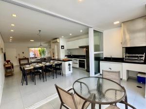 a kitchen and dining room with a table and chairs at Casa charmosa condomínio piscina Praia de Juquehy, São Sebastião in Juquei