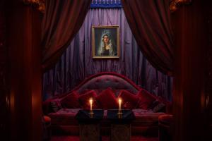 a living room with a red couch with two candles at Maison Athénée in Paris