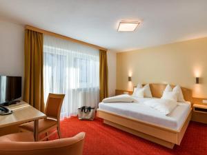 pokój hotelowy z dużym łóżkiem i biurkiem w obiekcie Sun Valley - Wildschönau w mieście Auffach