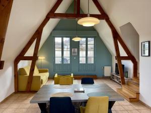 a living room with a table and chairs at Appartement le Saint-Nicolas Auxerre Les Quais in Auxerre