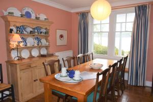 a dining room with a wooden table and chairs at Elm Cottage in Kippford