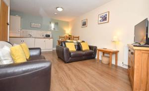 a living room with two leather chairs and a television at Romantic Escape and Stargazer's Hideaway nr Dark Sky, Alnwick, Kielder in Alnham