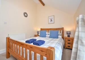 a bedroom with a wooden bed with blue pillows at Romantic Escape and Stargazer's Hideaway nr Dark Sky, Alnwick, Kielder in Alnham