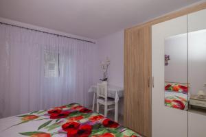 sypialnia z łóżkiem i stołem z krzesłem w obiekcie Apartman Đurđica w mieście Lovran