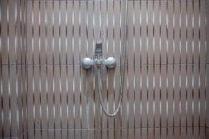 a shower attached to a wall with a hose at Hotel O Stasiun Cirebon Kejaksan Near Alun Alun Cirebon Formerly Family Homestay in Cirebon +27 photos