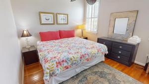 a bedroom with a bed and a dresser and a mirror at Host on the Coast in Folly Beach