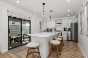 a kitchen with a large white counter and stools at Trackside Tranquility - TC522B in Solana Beach