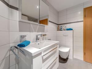 a white bathroom with a sink and a toilet at Haus Berlin, Wohnung 2 in Loddin +11 photos