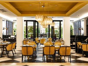 a restaurant with tables and chairs and a chandelier at Sofitel Paris Le Faubourg in Paris