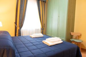 una camera da letto con un letto blu con asciugamani sopra di Villa Serena-250metri dal mare -Wifi- Free Parking a Lido Di Fondi