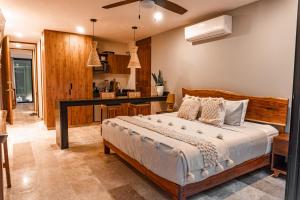 a bedroom with a bed and a kitchen at Premium Apartment in Tulum 2 Bedrooms Roof Top Pool - Aldea Zama in Tulum
