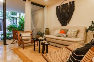 a living room with a couch and a table at Premium Apartment in Tulum 2 Bedrooms Roof Top Pool - Aldea Zama in Tulum