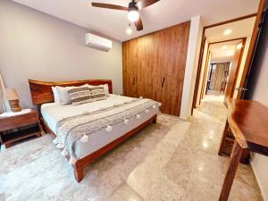 a bedroom with a bed and a wooden wall at Premium Apartment in Tulum 2 Bedrooms Roof Top Pool - Aldea Zama in Tulum