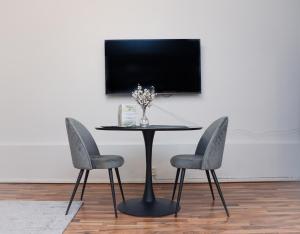 un tavolo con due sedie e una TV a parete di Spacious Cozy Corner a Helsinki