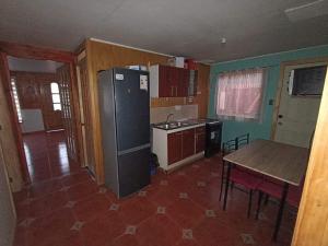 a kitchen with a refrigerator and a table in it at Descanso Familiar in Llanquihue