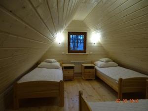 a room with two beds and a window in a attic at Ośrodek Wypoczynkowy Inco in Międzywodzie