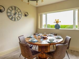a dining room with a table and chairs and a clock at The Poplars in Catwick