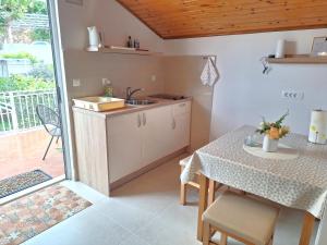 a kitchen and dining room with a table and a balcony at Apartments Boris in Zaton