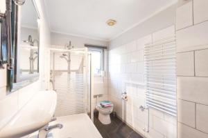 a white bathroom with a toilet and a sink at Ferienwohnung Franke 1 3 in Zinnowitz +12 photos