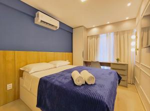 a bedroom with a bed with two towels on it at Rio Park Avenue, Espaço Familia - by TRH Home Stay in Recife +17 photos