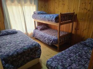 a room with three bunk beds in a cabin at Casa Quinta El Tabo in El Tabo