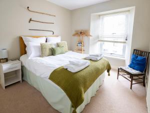 ein Schlafzimmer mit einem großen Bett mit Handtüchern darauf in der Unterkunft Rose Cottage in Cardigan