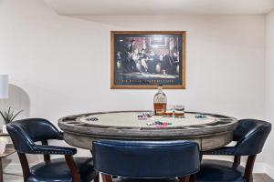a room with a table with chairs and a bottle of whiskey at Modern Retreat Games BBQ Grill Close to Downtown in Omaha