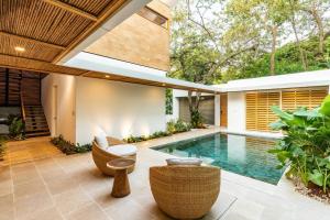 an outdoor patio with a swimming pool and a house at Green House 2 in Nicoya