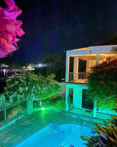 a swimming pool in front of a house at night at LA VITRINE Hotel in São Gabriel da Cachoeira