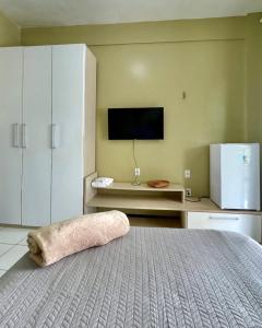 a bedroom with a bed and a tv on the wall at LA VITRINE Hotel in São Gabriel da Cachoeira