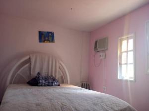 a bedroom with a bed with a pillow on it at Sítio jardim in São Pedro da Aldeia