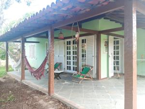 a house with a patio with a roof at Sítio jardim in São Pedro da Aldeia