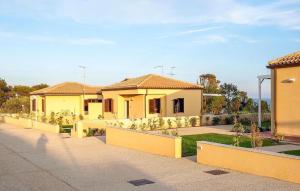 ein gelbes Haus mit einem Zaun davor in der Unterkunft Pet Friendly Home In Marina Di Modica in Marina di Modica + 13 Fotos