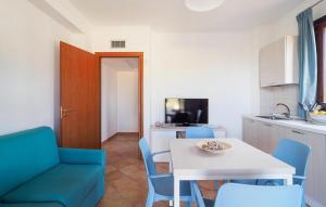 eine Küche und ein Esszimmer mit einem Tisch und blauen Stühlen in der Unterkunft Pet Friendly Home In Marina Di Modica in Marina di Modica