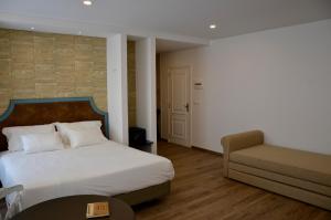 ein Schlafzimmer mit einem Bett, einer Couch und einem Stuhl in der Unterkunft VILA TOCA by brugrani in Funchal + 28 Fotos
