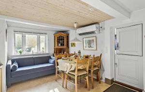 a living room with a table and a blue couch at Gorgeous Home In Marstal With Wifi in Marstal