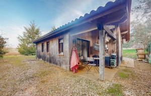 a small shack with a table and an umbrella at Awesome Home In Val De Louyre Et Caude in Saint-Alvère