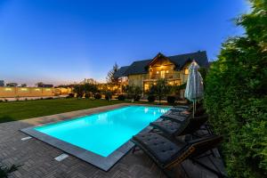 a swimming pool in the backyard of a house at Orchard Villa in Braşov