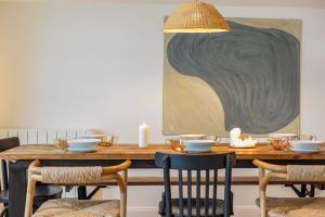 a dining room table with a large painting on the wall at Appartement Mer et Pierres - Welkeys in Saint-Jean-de-Luz
