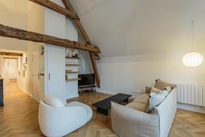 a living room with two white chairs and a table at Appartement Mer et Pierres - Welkeys in Saint-Jean-de-Luz