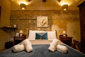 a bedroom with a bed with two pillows on it at Il figolla farmhouse in Xagħra
