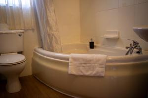 a bathroom with a tub and a toilet and a sink at Il figolla farmhouse in Xagħra