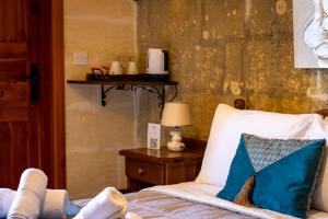 a bedroom with a bed and a table with a lamp at Il figolla farmhouse in Xagħra