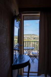 a room with a view of a balcony with a table at Il figolla farmhouse in Xagħra