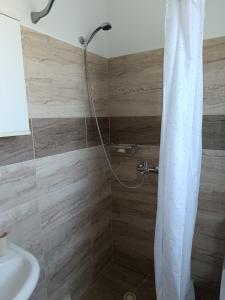 a shower with a white shower curtain in a bathroom at Haraki Blue Houses in Haraki +20 photos
