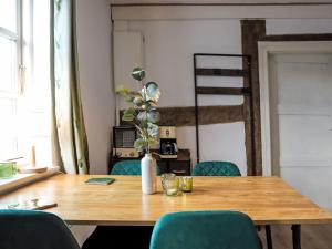 a wooden table with chairs and a vase with a plant at Apartment Luise by Interhome in Mirow +23 photos