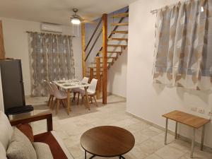 a living room with a table and a dining room at Haraki Blue Houses in Haraki